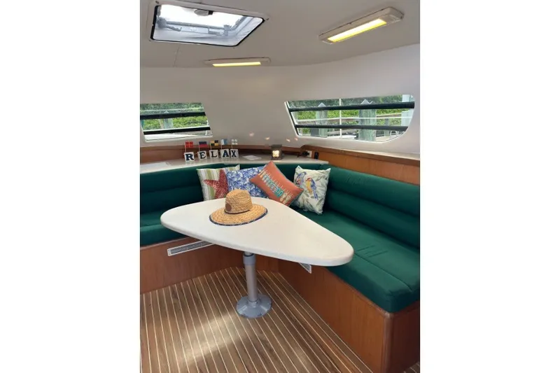 Slide: The Image of Cozy interior of 2004 Manta 42 MkII yacht with green seating and decorative pillows. - 24