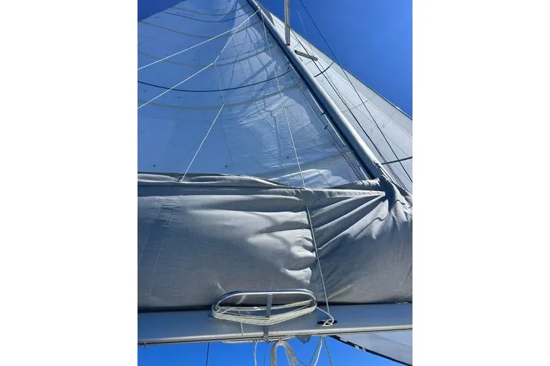 Slide: The Image of Sail of a 2004 Manta 42 MkII catamaran against a clear blue sky. - 73