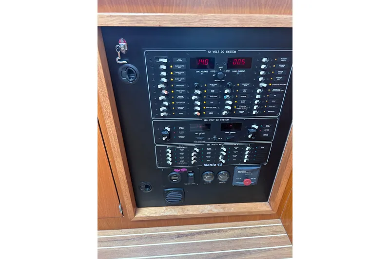 Slide: The Image of Electrical control panel of a 2004 Manta 42 MkII yacht, featuring switches and gauges. - 26