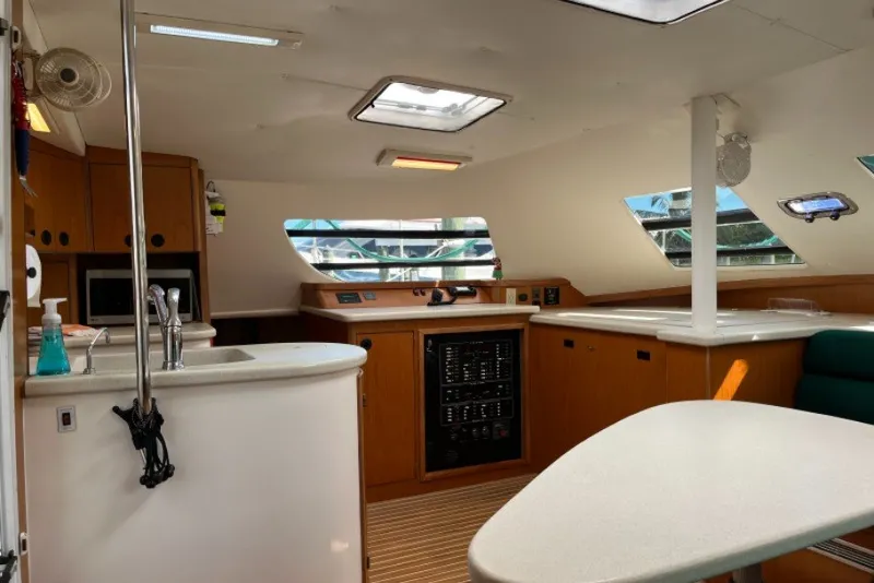Slide: The Image of Interior of 2004 Manta 42 MkII catamaran, featuring modern kitchen and navigation area. - 27