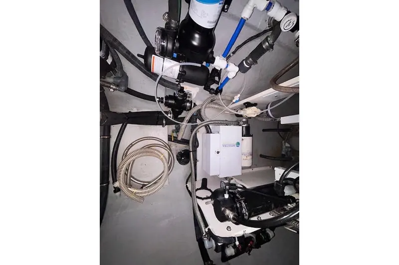 Slide: The Image of Engine room of a 2004 Manta 42 MkII with various mechanical components and hoses. - 42