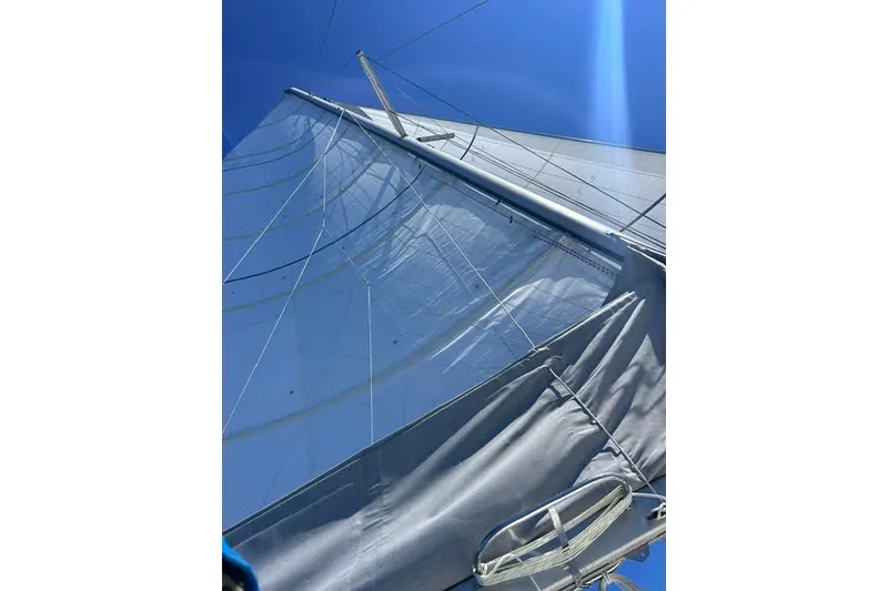 Slide: The Image of Sail of a 2004 Manta 42 MkII catamaran against a clear blue sky. - 74