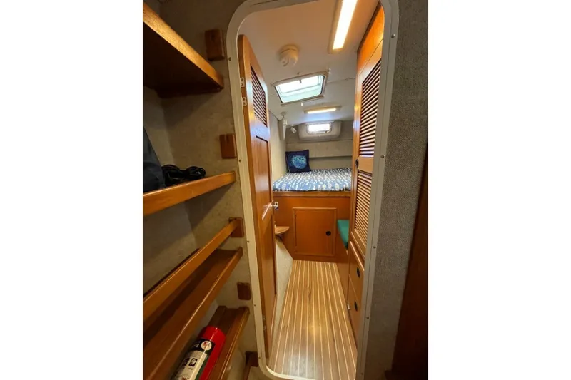 Slide: The Image of Interior of 2004 Manta 42 MkII yacht cabin with wooden shelves and cozy bed. - 26