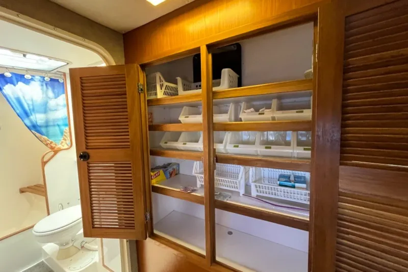 Slide: The Image of Wooden cabinet with open louvered doors in 2004 Manta 42 MkII yacht bathroom. - 51