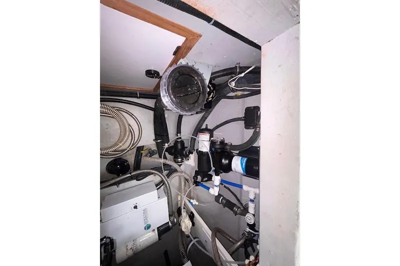 Slide: The Image of Engine room of a 2004 Manta 42 MkII sailboat, showcasing mechanical components and piping. - 44