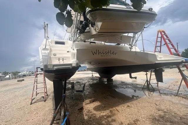 Slide: The Image of Manta 42 MkII catamaran from 2004 on dry dock, with ladders and overcast sky. - 48