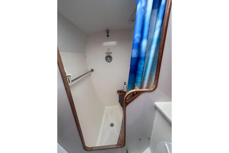 Slide: The Image of Shower area in 2004 Manta 42 MkII yacht with blue curtain and wooden accents. - 31