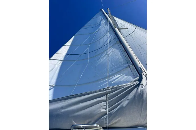 Slide: The Image of Sail of a 2004 Manta 42 MkII catamaran against a clear blue sky. - 75