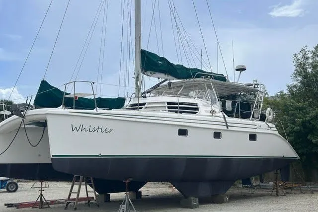 Slide: The Image of 2004 Manta 42 MkII catamaran named "Whistler" on dry dock with green covers. - 47