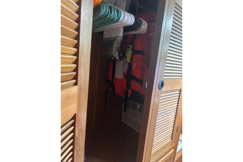 Slide: The Image of Wooden closet on 2004 Manta 42 MkII yacht with life jackets and hangers. - 23