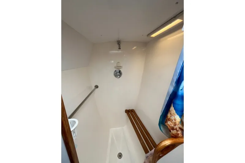 Slide: The Image of Shower area in 2004 Manta 42 MkII yacht, featuring a wooden bench and grab bar. - 38