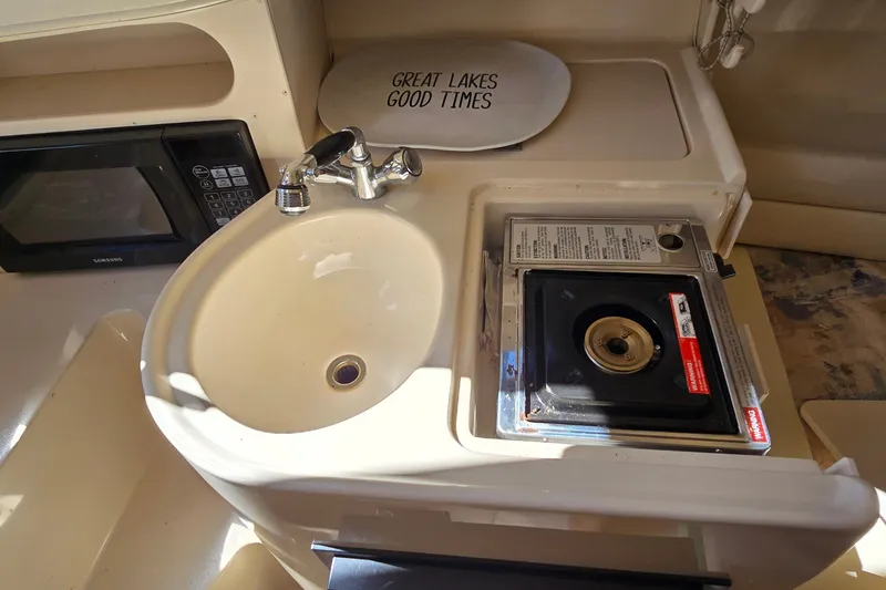 Slide: The Image of 2003 Grady-White Sailfish 282 boat kitchen with sink, stove, and microwave. - 26
