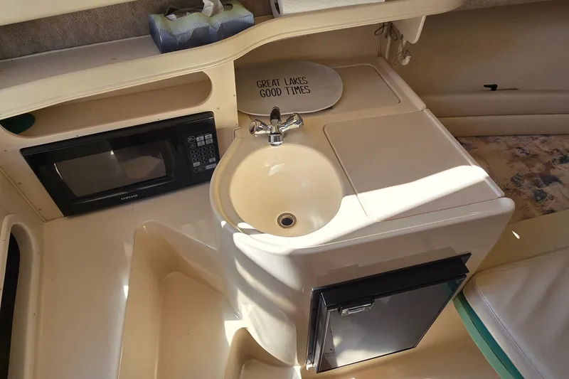 Slide: The Image of 2003 Grady-White Sailfish 282 cabin with sink, microwave, and mini fridge. - 20
