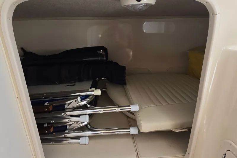Slide: The Image of Storage compartment in a 2003 Grady-White Sailfish 282 boat with folded chairs and cushions. - 21
