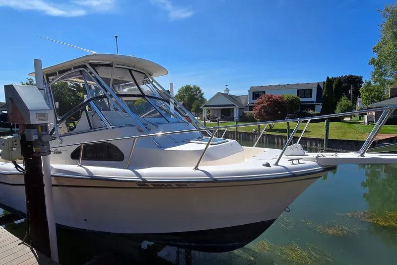 Slide: The Image of 2003 Grady-White Sailfish 282 boat docked in a serene residential canal. - 1