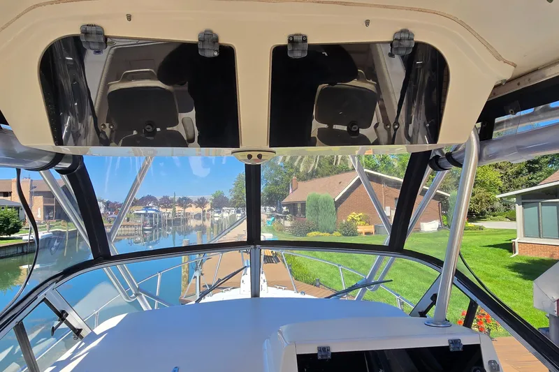 Slide: The Image of 2003 Grady-White Sailfish 282 boat interior with waterfront view and residential backdrop. - 10