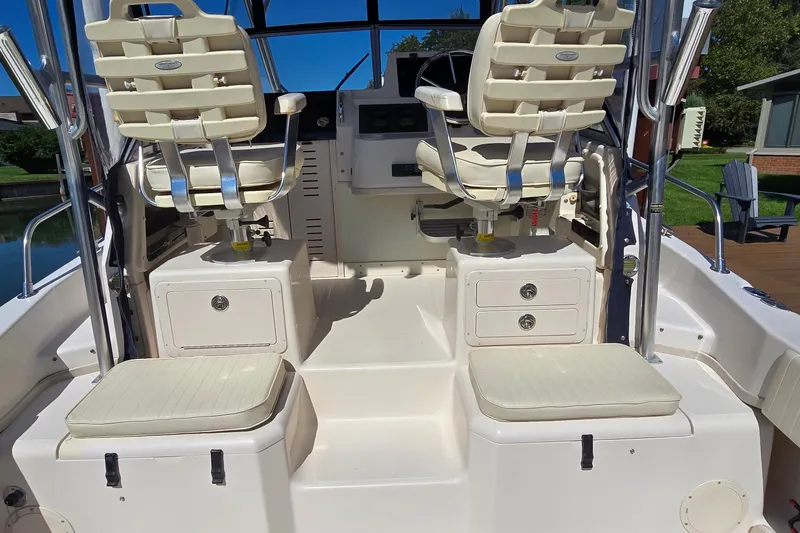 Slide: The Image of 2003 Grady-White Sailfish 282 boat interior with dual captain chairs and storage compartments. - 17