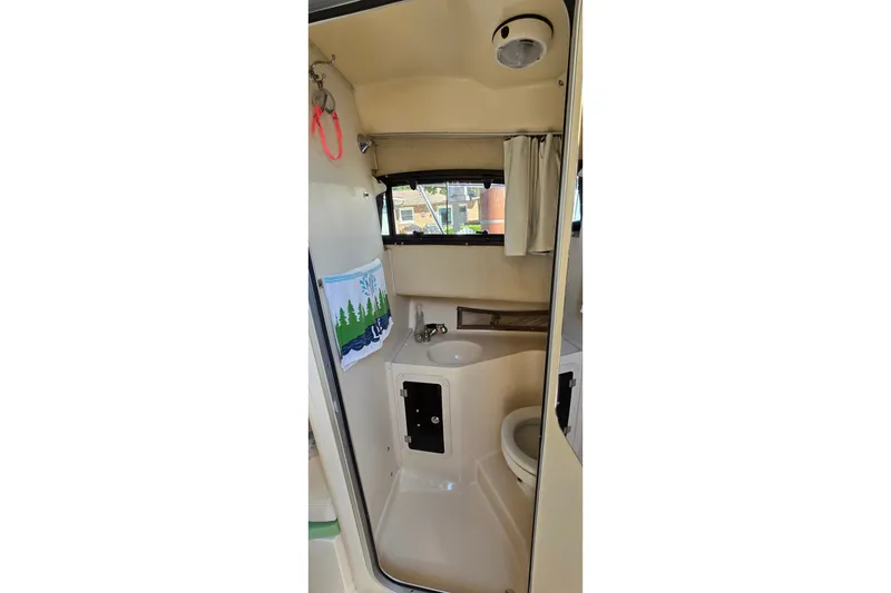 Slide: The Image of 2003 Grady-White Sailfish 282 boat bathroom interior with sink and toilet. - 24
