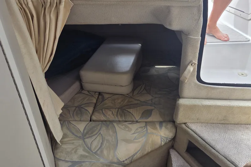 Slide: The Image of 1999 Four Winns 258 Vista cabin interior with floral-patterned cushions and beige curtains. - 17