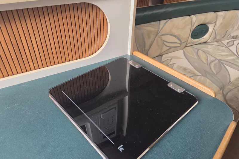 Slide: The Image of 1999 Four Winns 258 Vista cabin interior with sleek black panel and patterned seating. - 15