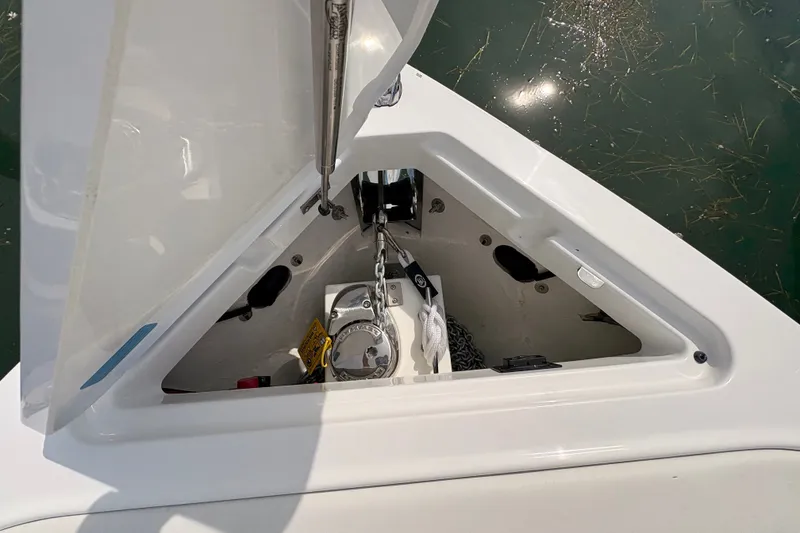 Slide: The Image of 2026 Cobalt R6 Outboard anchor compartment with chain and rope, open hatch view. - 15