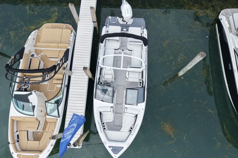 Slide: The Image of Aerial view of 2026 Cobalt R6 Outboard boat docked beside another vessel. - 4