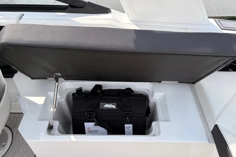 Slide: The Image of Open storage compartment on 2026 Cobalt R6 Outboard boat with black bag inside. - 11