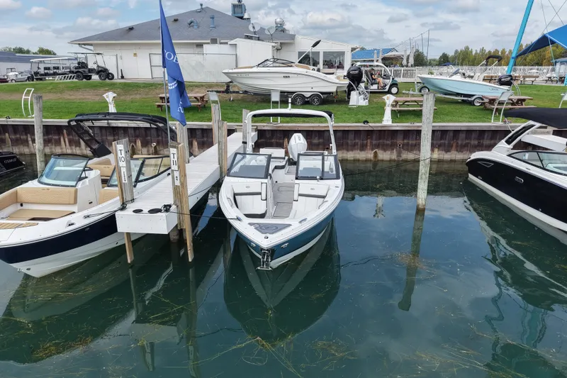 Slide: The Image of 2026 Cobalt R6 Outboard boat docked at marina, surrounded by other boats. - 5