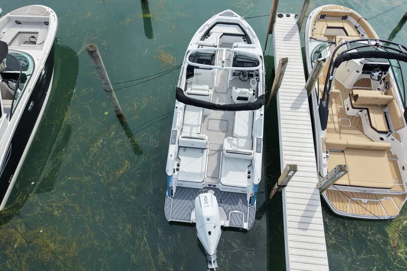 Slide: The Image of 2026 Cobalt R6 Outboard boat docked, aerial view, surrounded by clear water and neighboring boats. - 3