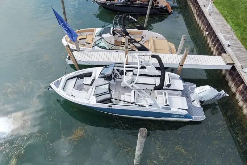 Slide: The Image of 2026 Cobalt R6 Outboard boat docked in clear water marina. - 2