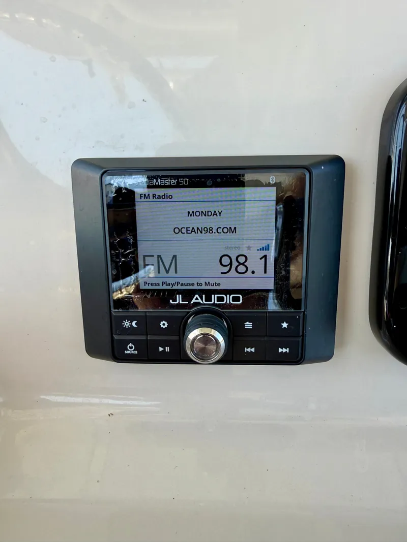 Slide: The Image of A JL Audio radio on a boat displaying FM 98.1. - 14