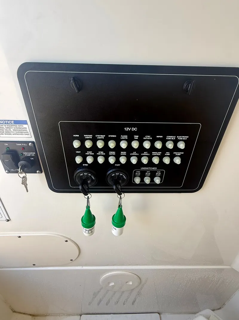 Slide: The Image of Control panel of a 2024 Boston Whaler 250 Outrage with various switches and indicator lights. - 23