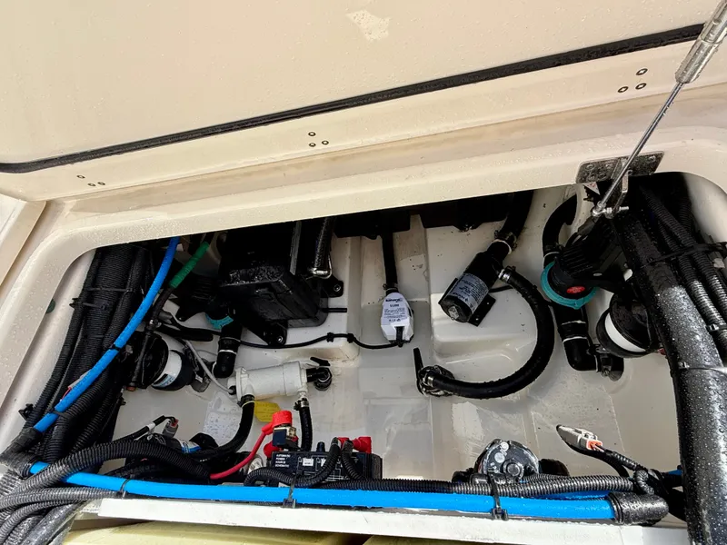 Slide: The Image of View inside the engine compartment of a 2024 Boston Whaler 250 Outrage, showing cables and components. - 35