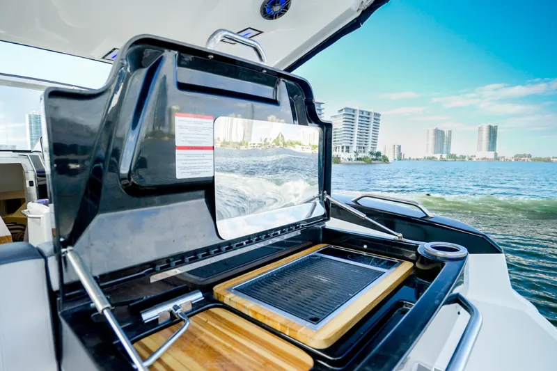 Slide: The Image of Luxury yacht Granfort 370 GTX 2026 with onboard grill, overlooking city skyline and ocean. - 19