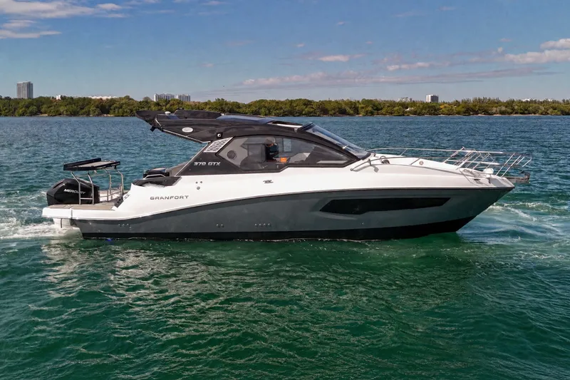 The Image of 2026 Granfort 370 GTX luxury yacht cruising on a serene lake under a clear sky. - 0