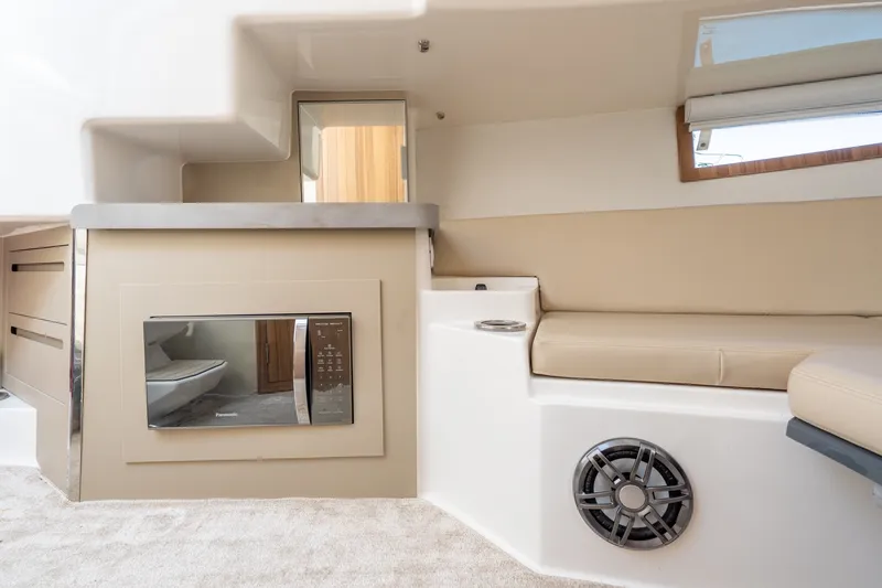 Slide: The Image of Interior of the 2026 Granfort 370 GTX with beige sofa, speaker, and window. - 26