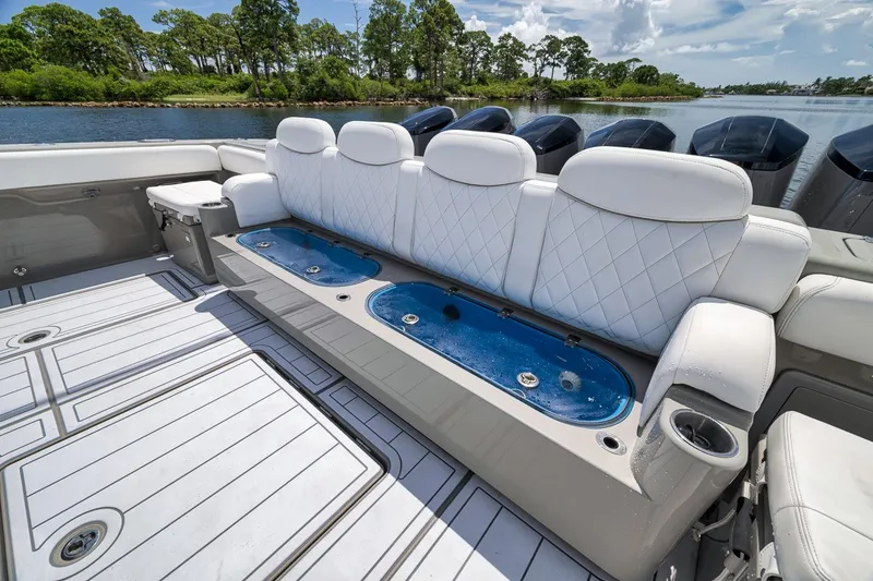Slide: The Image of Luxurious seating on 2023 HCB 65 Estrella boat with elegant white upholstery and scenic water backdrop. - 75