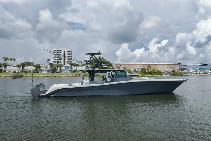 Slide: The Image of 2023 HCB 65 Estrella luxury boat cruising on a calm waterway under cloudy skies. - 12