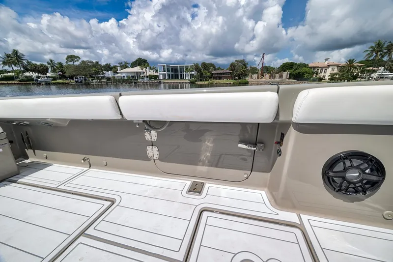 Slide: The Image of 2023 HCB 65 Estrella boat deck with seating, speaker, and scenic waterfront view. - 64