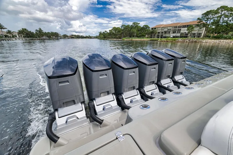 Slide: The Image of Five powerful outboard motors on a 2023 HCB 65 Estrella boat cruising on water. - 60