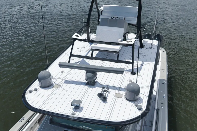 Slide: The Image of 2023 HCB 65 Estrella boat with sleek deck design on calm water. - 19