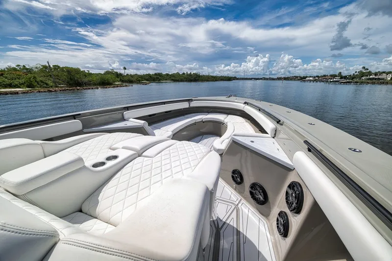 Slide: The Image of Luxurious 2023 HCB 65 Estrella boat interior with plush seating on a serene waterway. - 44