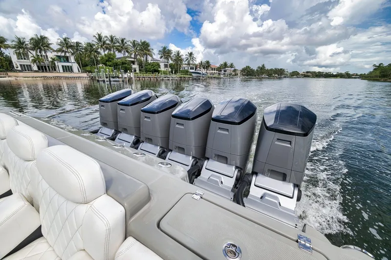 Slide: The Image of 2023 HCB 65 Estrella boat with five powerful outboard engines on a scenic waterway. - 61