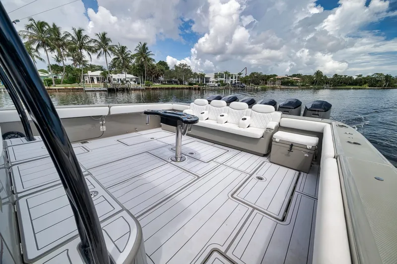 Slide: The Image of Luxurious 2023 HCB 65 Estrella boat deck with seating, set against a scenic waterfront view. - 55