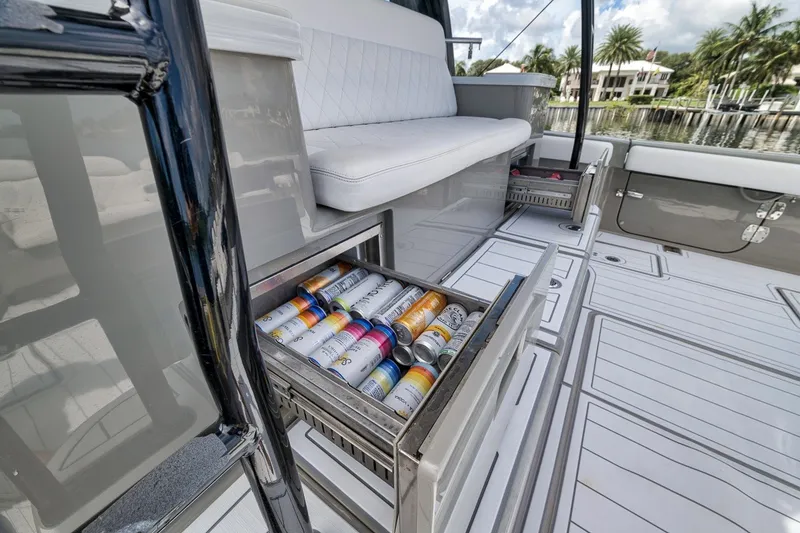 Slide: The Image of 2023 HCB 65 Estrella yacht with open beverage drawer, luxurious seating, and scenic waterfront view. - 62