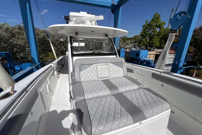 Slide: The Image of 2016 Everglades 435 Center Console boat with cushioned seating and Garmin equipment. - 7