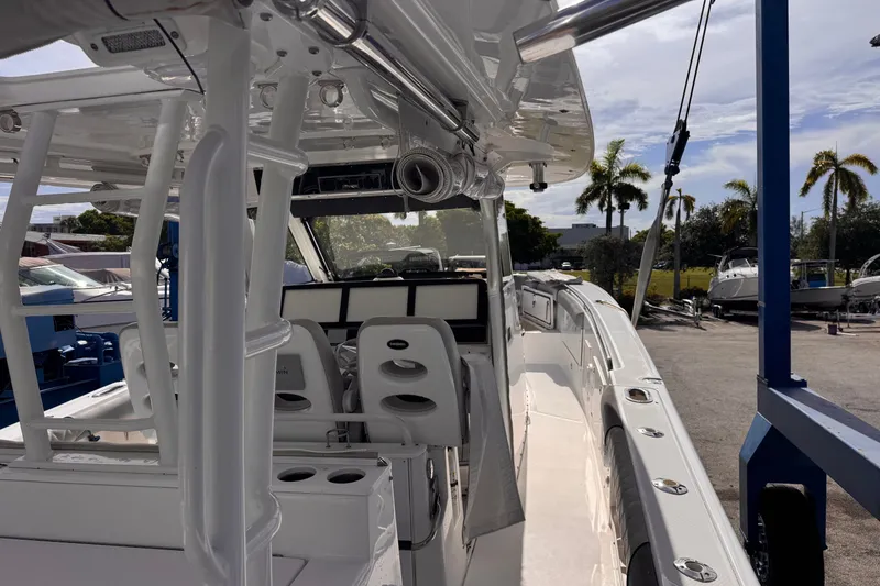 Slide: The Image of 2016 Everglades 435 Center Console boat interior with helm and seating, docked under sunny skies. - 15