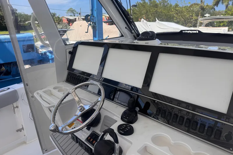 Slide: The Image of Control panel of a 2016 Everglades 435 Center Console boat with steering wheel and displays. - 18