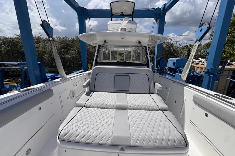 Slide: The Image of 2016 Everglades 435 Center Console boat with cushioned seating under a blue sky. - 9