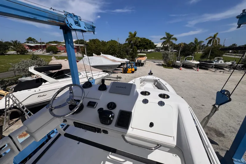 Slide: The Image of 2016 Everglades 435 Center Console boat on a lift, surrounded by other boats. - 22